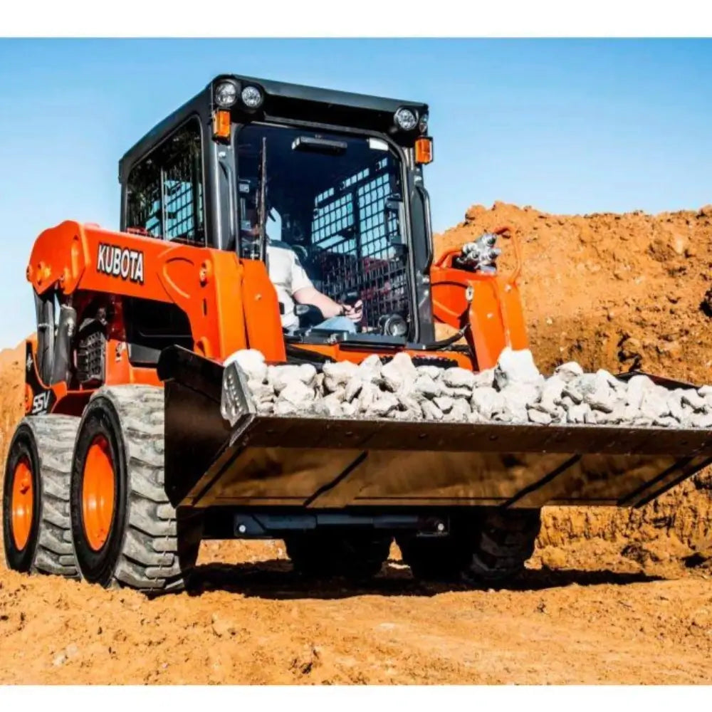 Orange Kubota SVL75 in a dirt pit with a buckle full of rocks.
