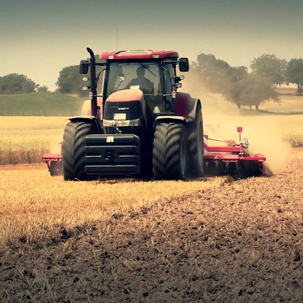 Case IH Magnum tractor pulling a ground breaker with farm land behind it